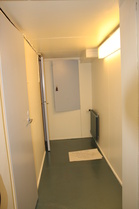 Käytävä nyt, lattialla varoitellaan uudesta maalipinnasta.