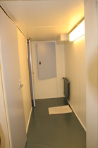 Käytävä nyt, lattialla varoitellaan uudesta maalipinnasta.